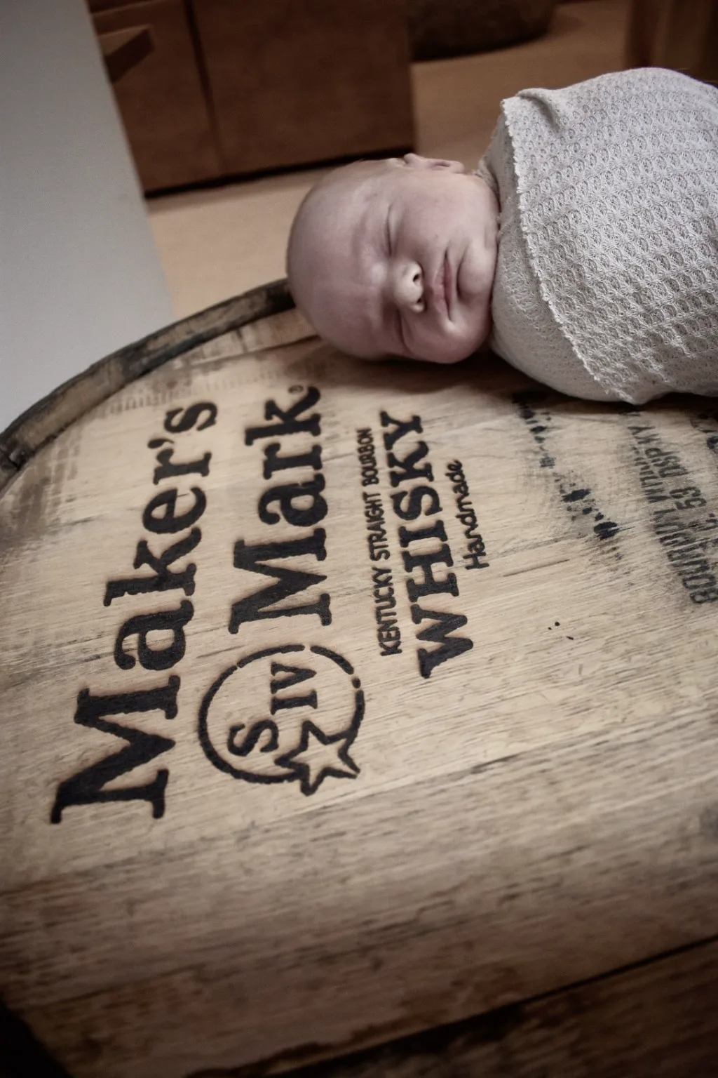 Close-up newborn portrait on an engraved whiskey barrel head