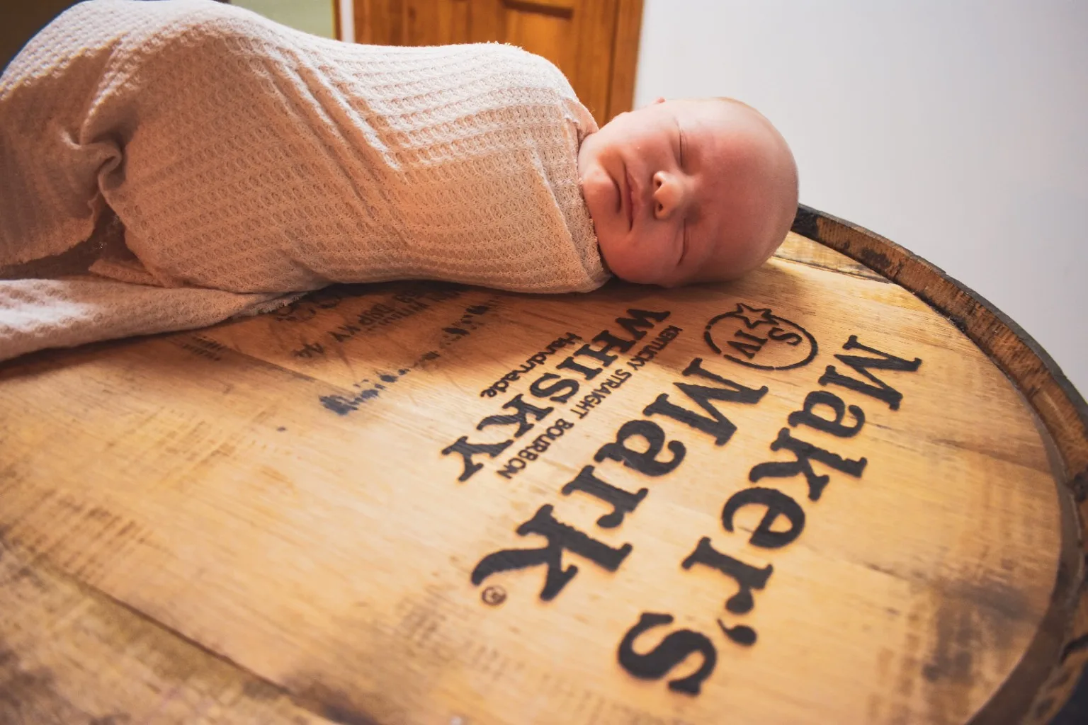 Newborn portrait on a Maker's Mark whiskey barrel head